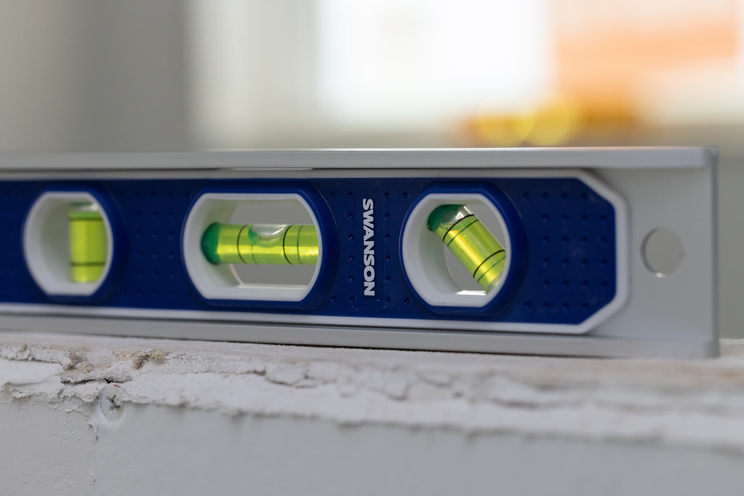 The Swanson TL002M Magnetic Extruded Aluminum Torpedo Level standing on a drywall edge.