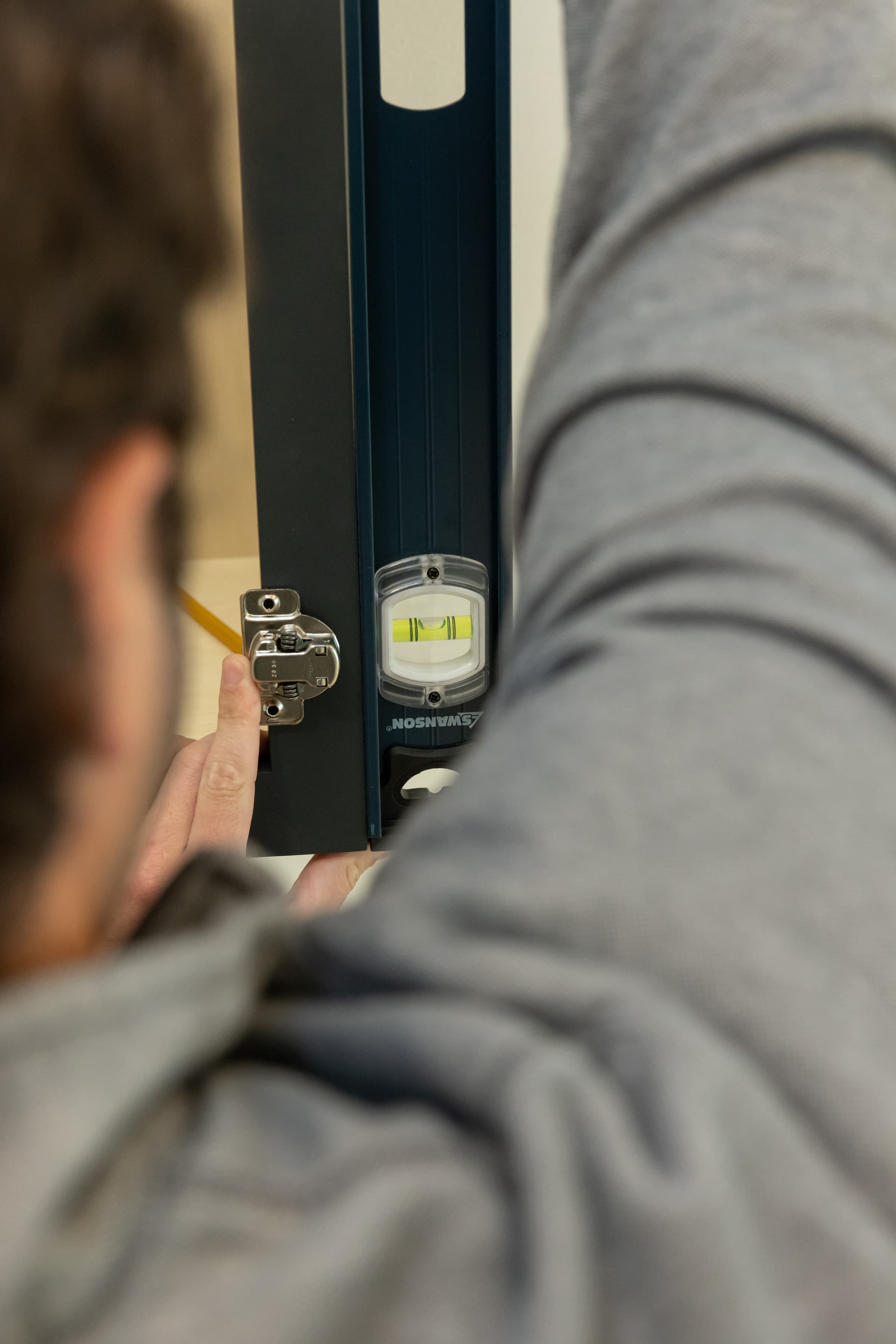 A trades pro using the Swanson IBL240 I-Beam Level on a job site.